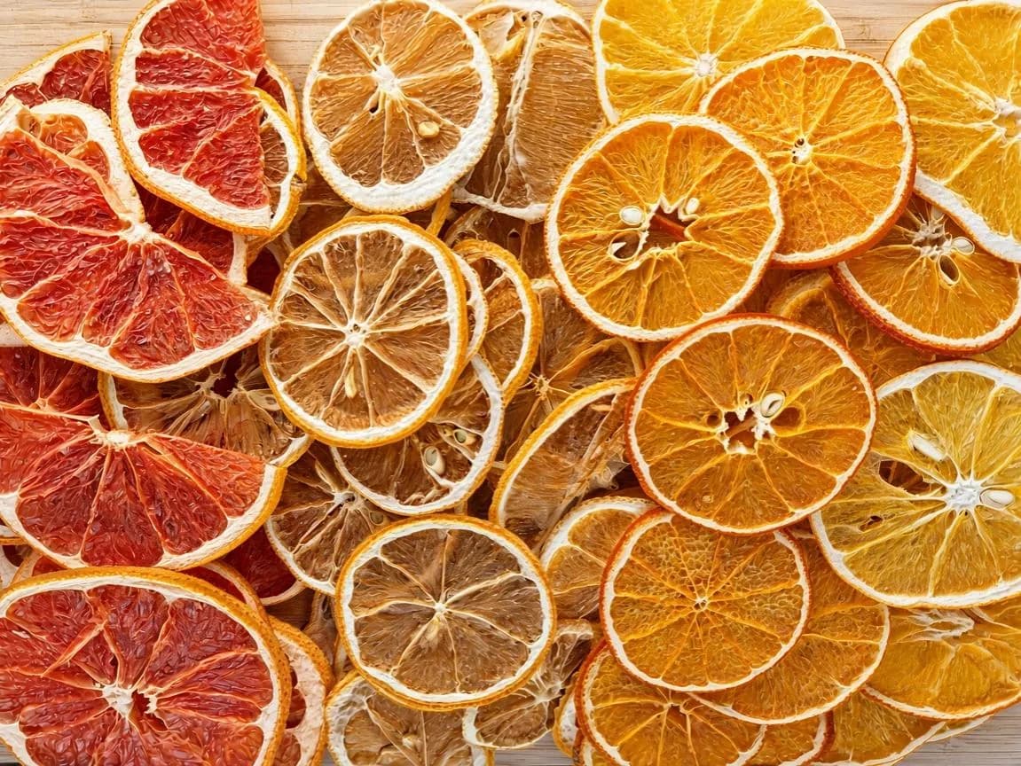 Rondelles d’agrumes séchées en vrac, oranges au premier plan.